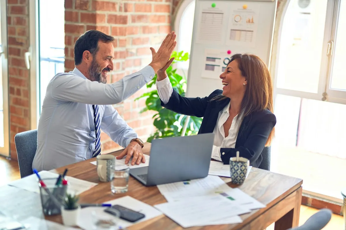 Business owners celebrating in a bright office