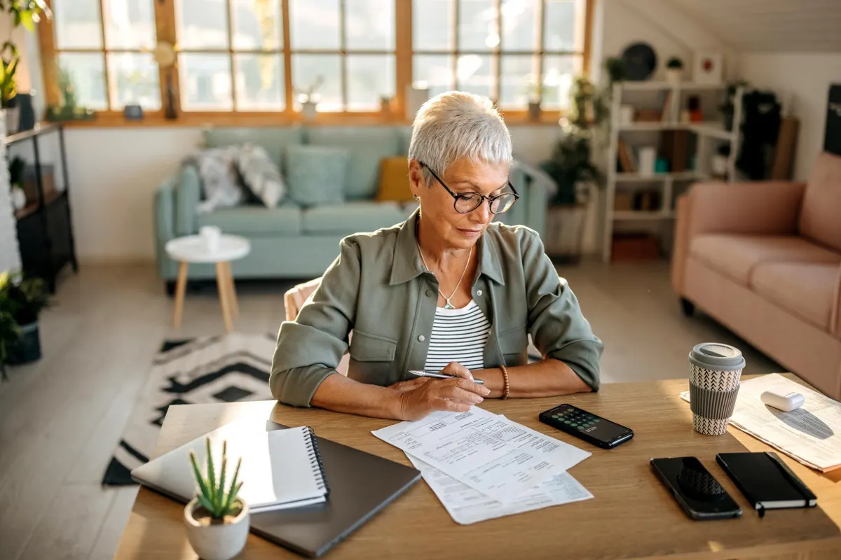 Retiree reviewing finances at a kitchen table