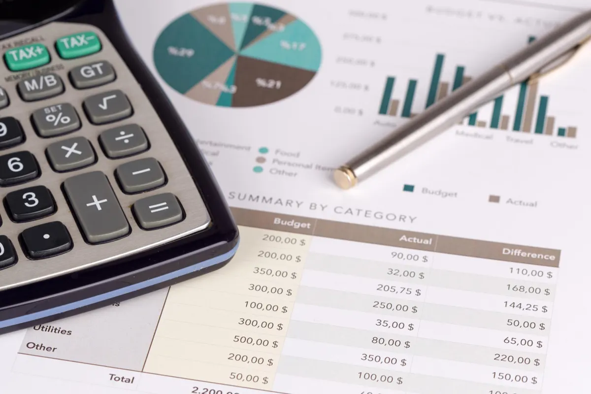 Printed budget report with charts and a calculator